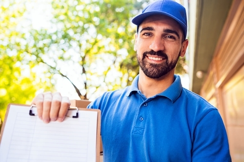 smiling technician holding contract